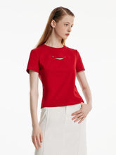 A lady wears a white skirt and a red shirt.